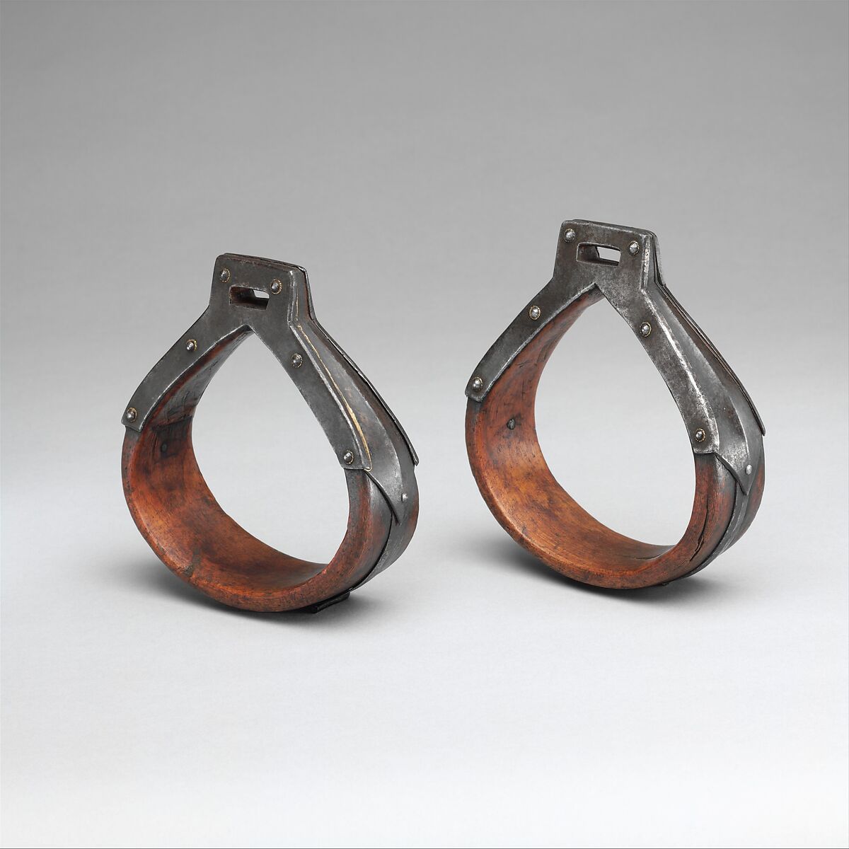 A pair of historic stirrups made from wood and metal